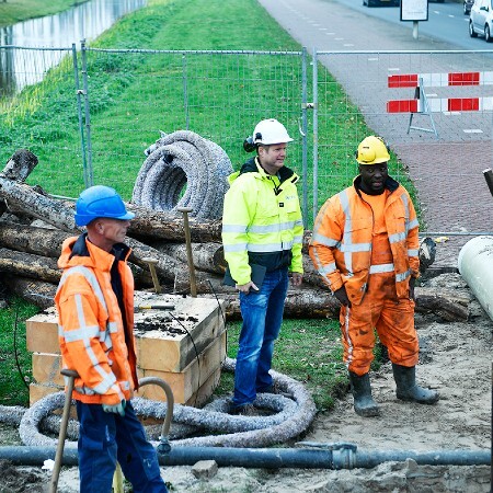 foto van 3 werkende mannen bij een rioolwerk