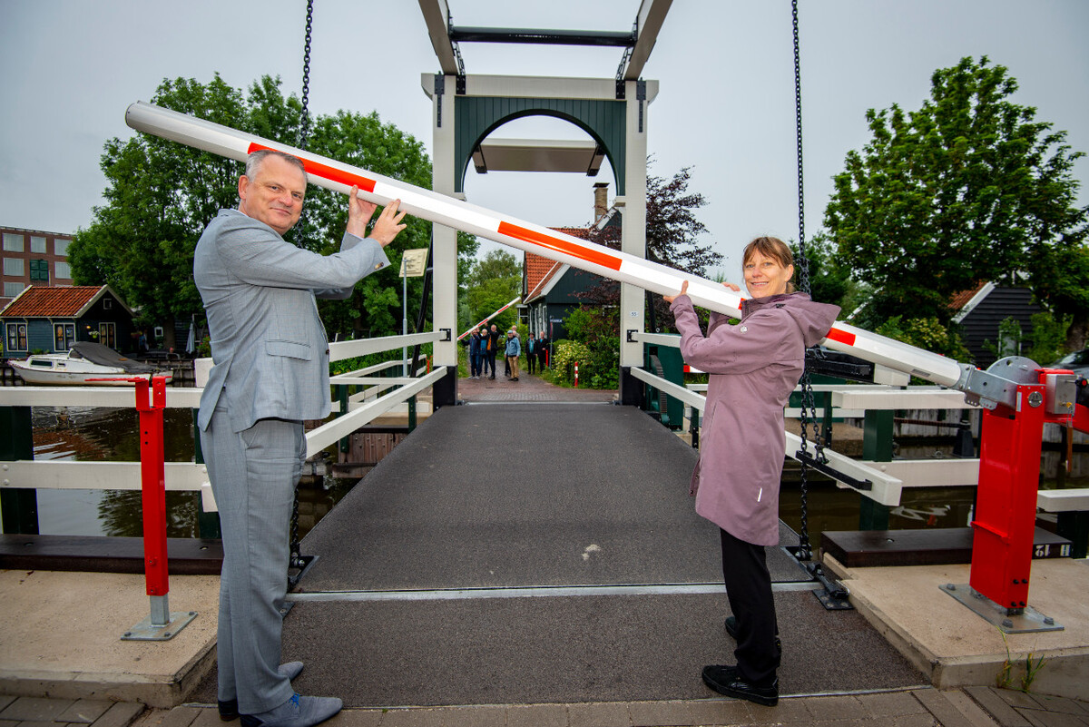 Foto van wethouders die de slagboom open zetten van de ophaalbrug Haaldersbroek